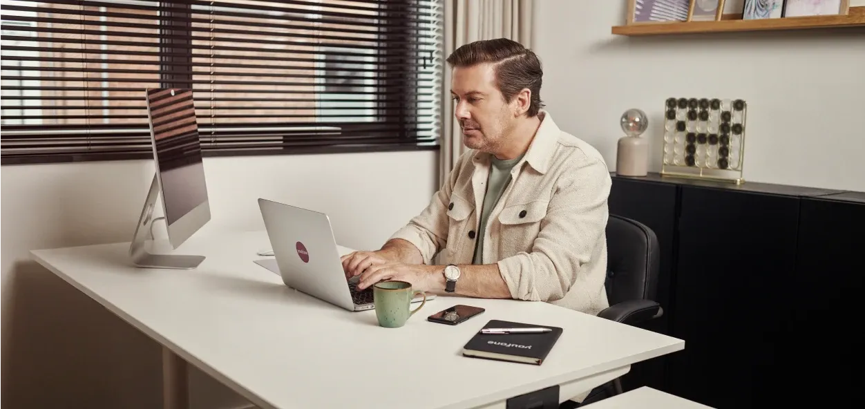 Man achter laptop